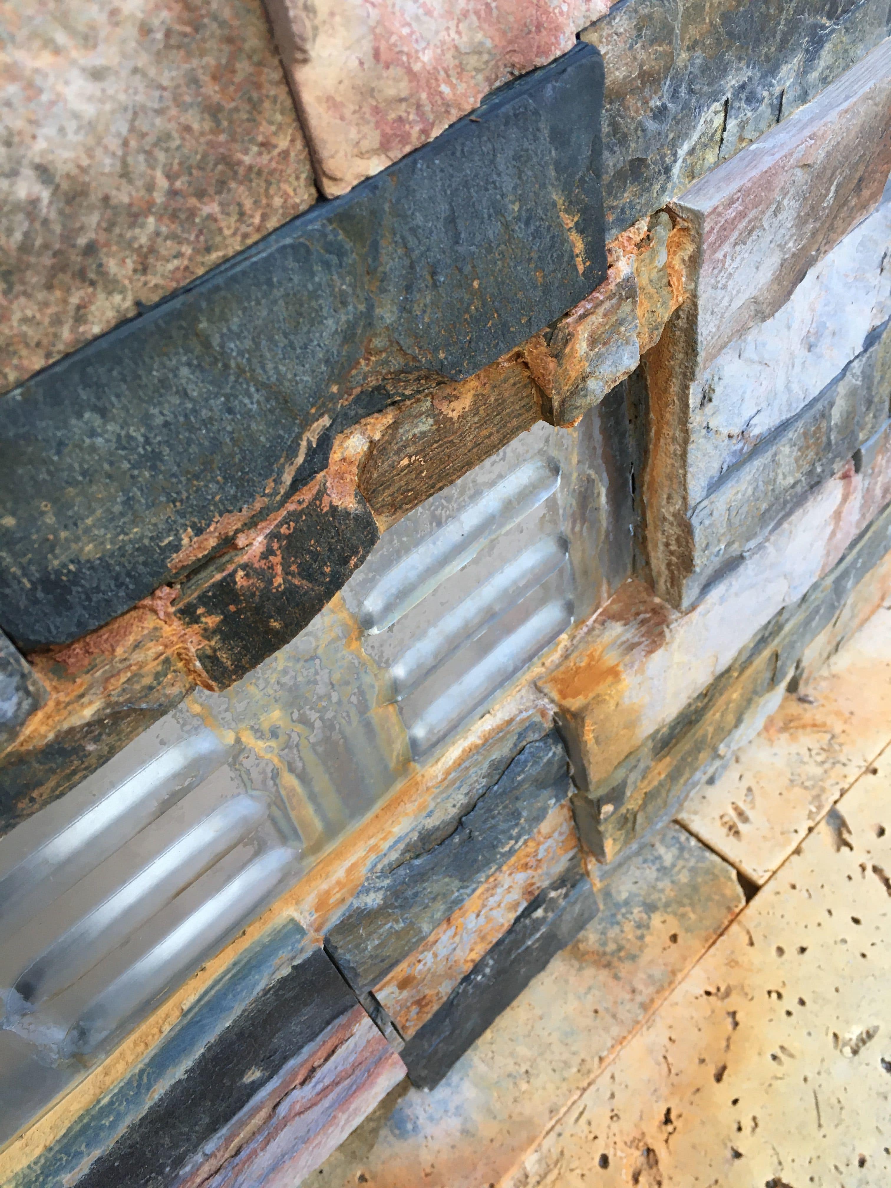 Rust on Stacked Stone Veneer caused by a metal grate